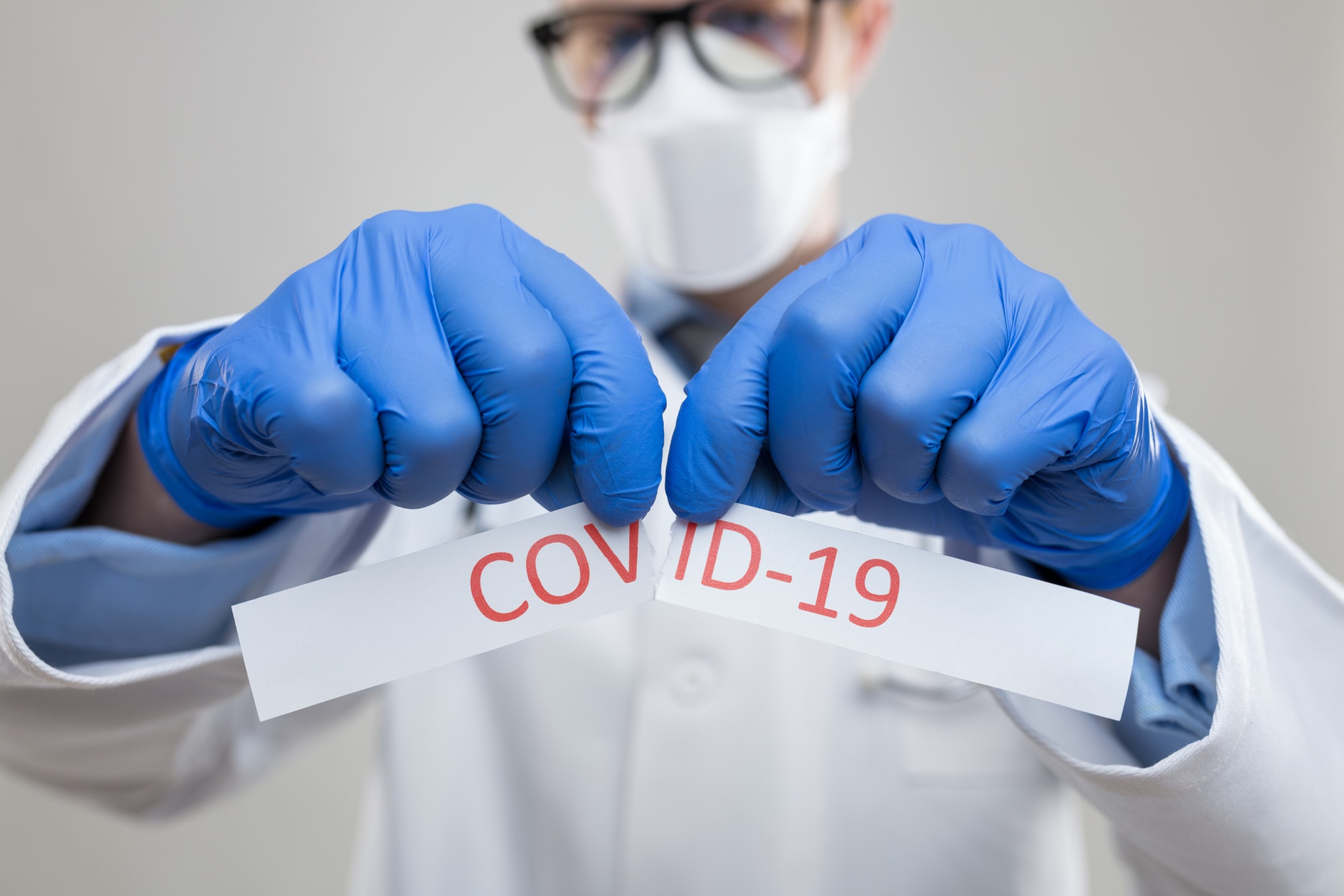 Doctor wearing respiratory mask and holding the Coronavirus blood sample